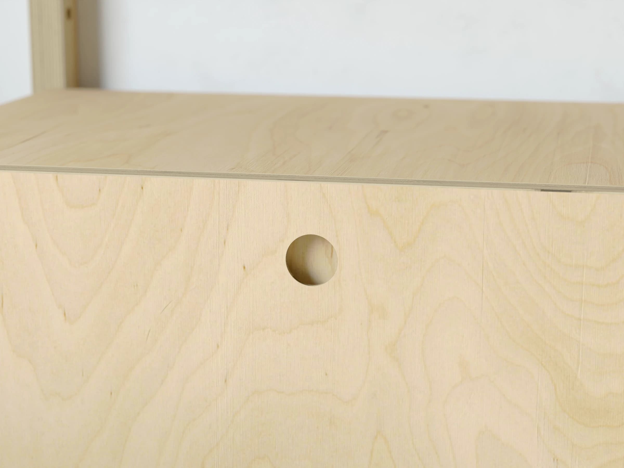 Close-up of a cabinet front with a circular-hole pull backed in Natural