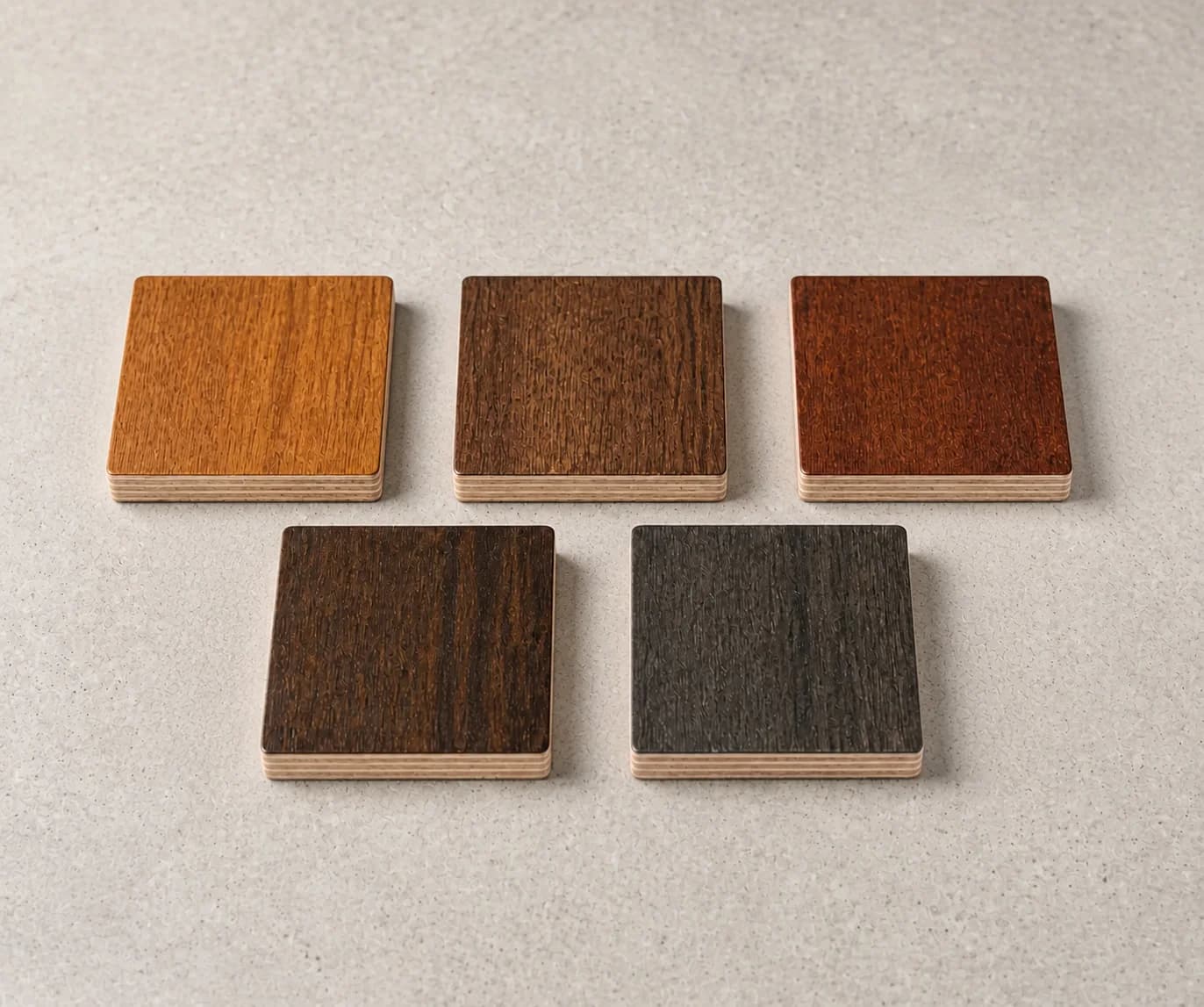 Five real dark-stained plywood finish samples arranged from warm brown to charcoal