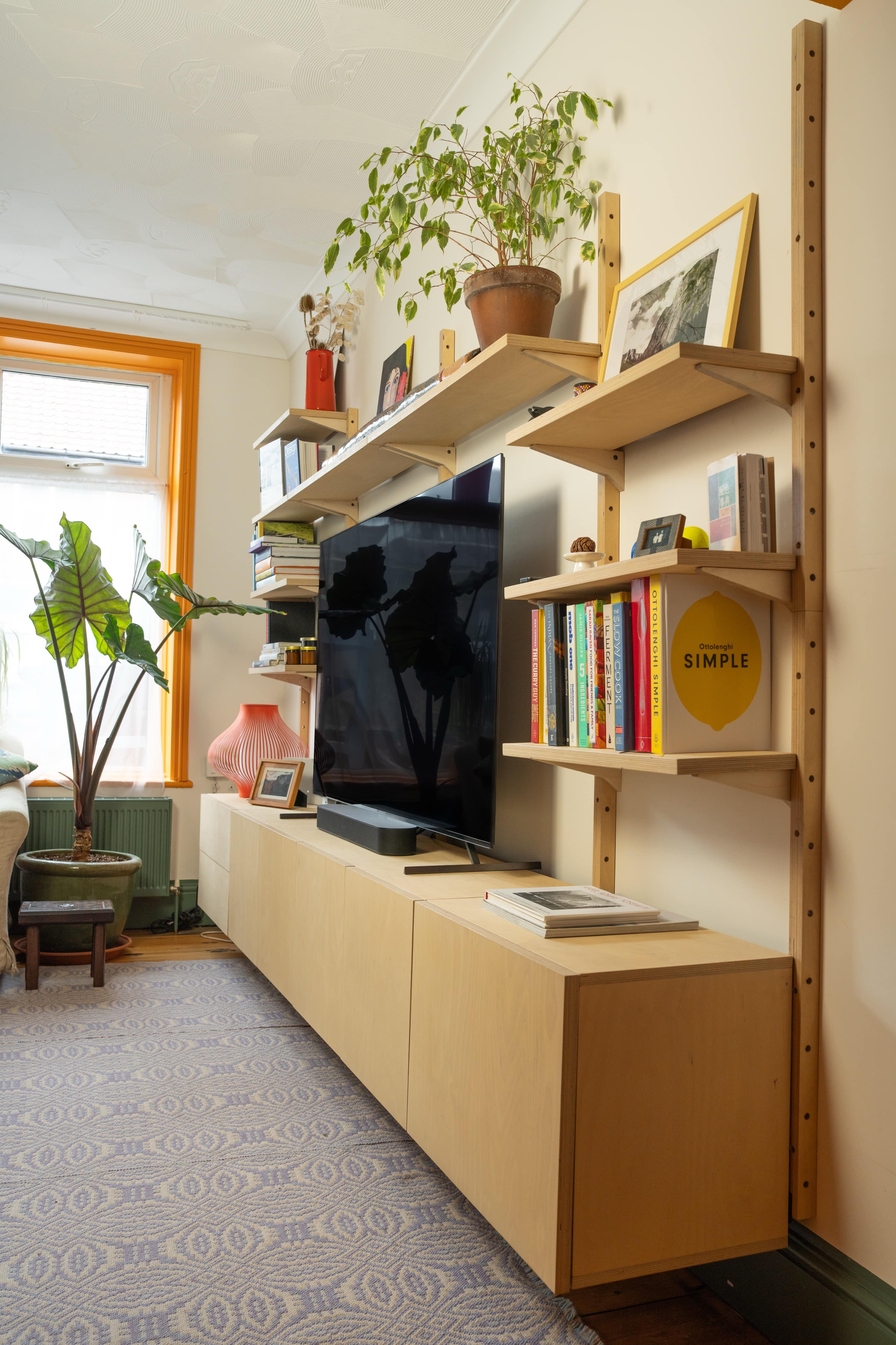 Mestra wall-mounted birch plywood shelving unit fitted on a living room wall
